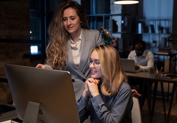 Two engineers reviewing a product on a monitor